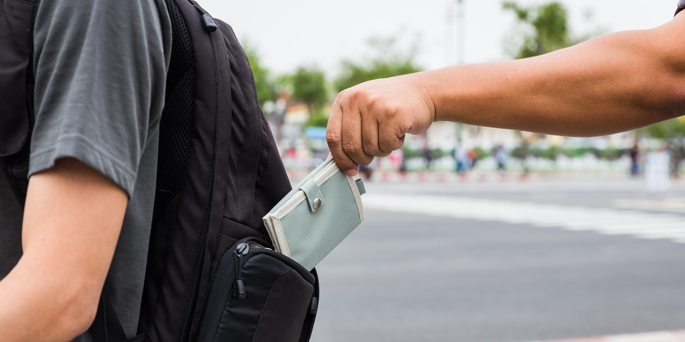 Man ist im wohlverdienten Urlaub und genießt die schönste Zeit des Jahres, und plötzlich ist alles weg: Geld, Papiere, Bank- und Kreditkarten – ein wahrgewordener Albtraum. | Diebstahl Mann mit Rucksack im Urlaub - ein Dieb klaut den Geldbeutel aus dem Rücksack.